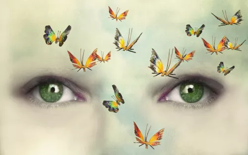 A flutter of butterflies across a light colored human face.