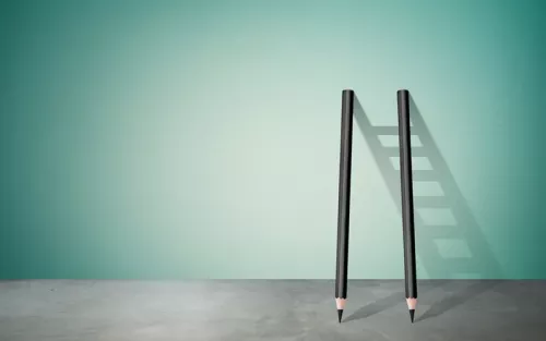 Two pencils leaned against a wall, their shadow forming a ladder.