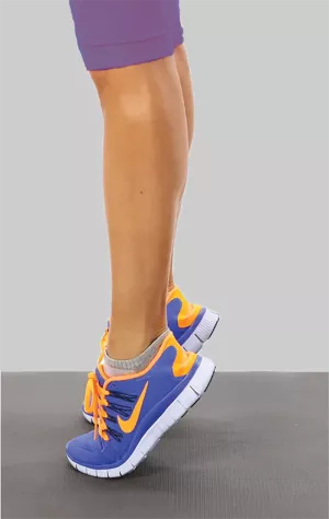 A person in blue running shoes raised up on their toes.