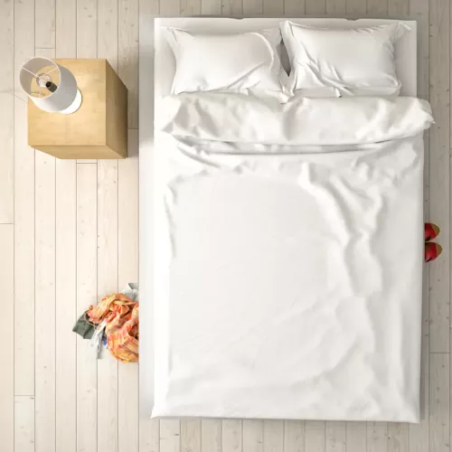 Aerial view of a crisp white bed in a room.