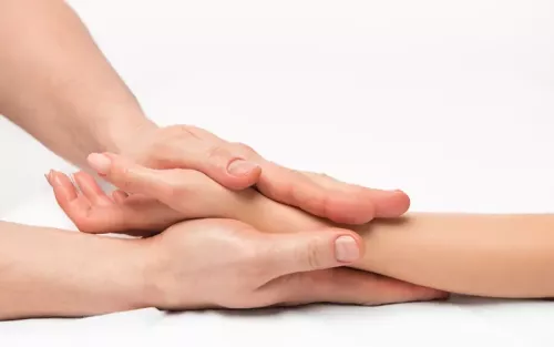 An MT using two hands to apply compression to a client's wrist and forearm.