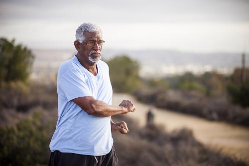 An African American man with light hair going running.