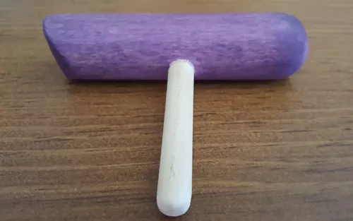 A purple wooden t-bar massage tool.