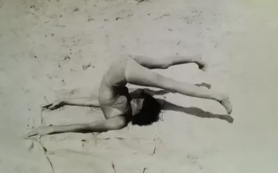Vered at a child, arching her back and legs practicing movement in the sand on the coast of the Mediterranean sea.