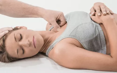 Til Luchau uses firm pressure with his thumb to evoke a Golgi response in a client.