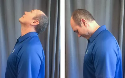 A man in a blue shirt tilts his head upward then downward, testing range of motion.