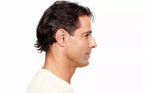 Lateral view of a man with wavy dark hair looking forward.