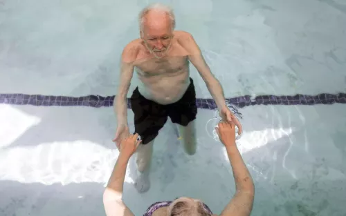 Harold Dull doing Watsu in the pool with another person.