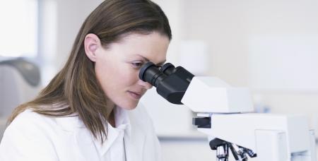 A woman looking into a microscope.