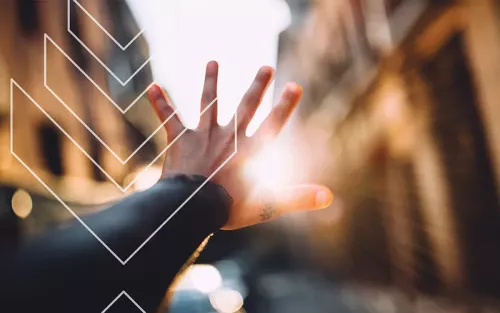 A hand with palm up and fingers splayed, blocking the sun.