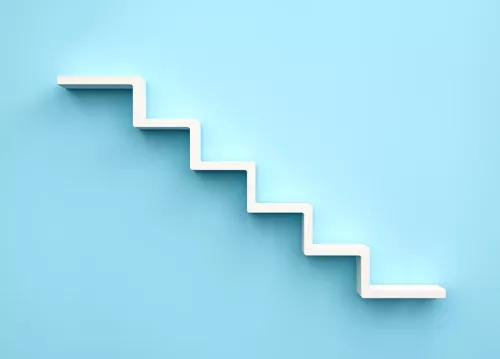 a pair of stairs descending left to right against a blue background.