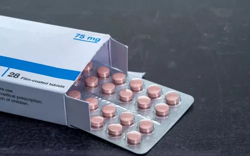 sleeve of pink statin pills inside a box.