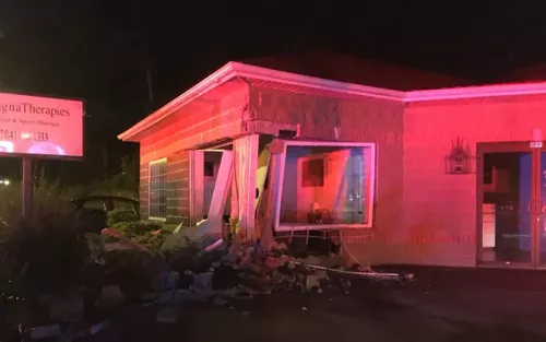 Exterior building damage to a massage practice at nighttime.