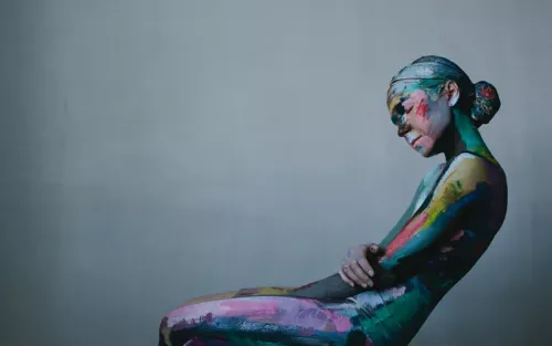 Abstract art of a woman covered in colorful body paint.
