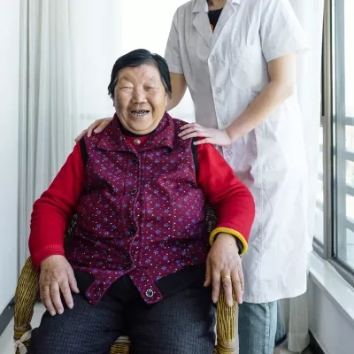 An older Asian woman receiving a chair massage.