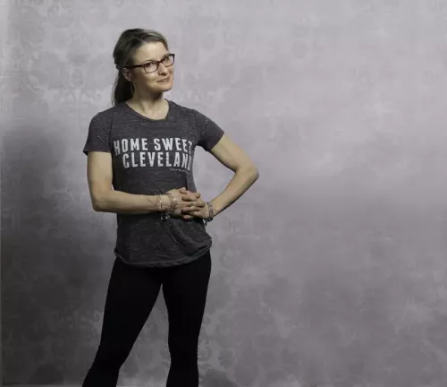 Jill Tschetter in a t-shirt, glasses, and dark jeans.
