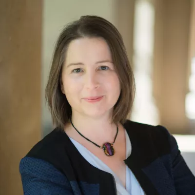 Rajam Roose poses in business attire with a slight smile.