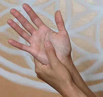 pushing on the acupressure point pericardium 8 in the center of the palm.