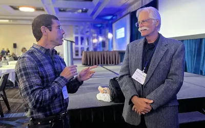 Author Whitney Lowe (left) talks with professor Stuart McGill, a keynote speaker at the FRC 6.