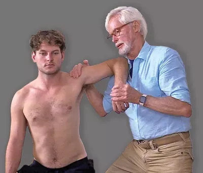 Erik Dalton performing internal/external rotations on a shirtless male client.