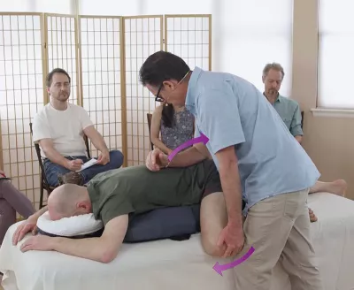 Til Luchau uses hip flexion and downward pressure on same-side ilium at the posterior superior iliac spine of a student client on a table..