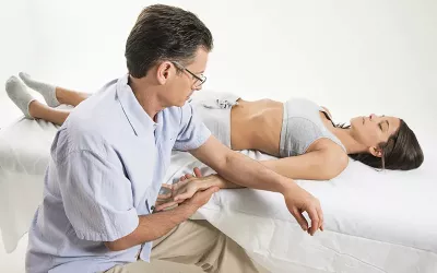 Til Luchau works on a supine client's wrist.