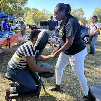 Kimberly Pettway performs chair massage on a client's hand.. 