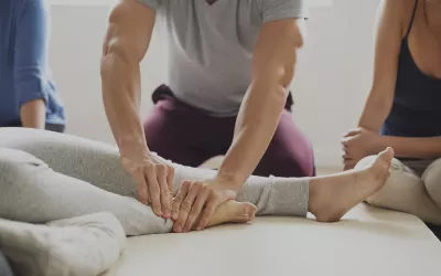 An MT addresses a client's foot as two others watch.