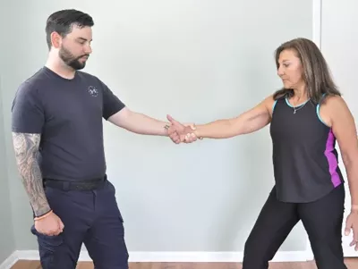 Author Teresa Matthews points her thumb upward as the client holds her wrist.